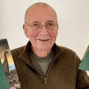 Portrett av Rune Timberlid som held ei bok i kvar hand